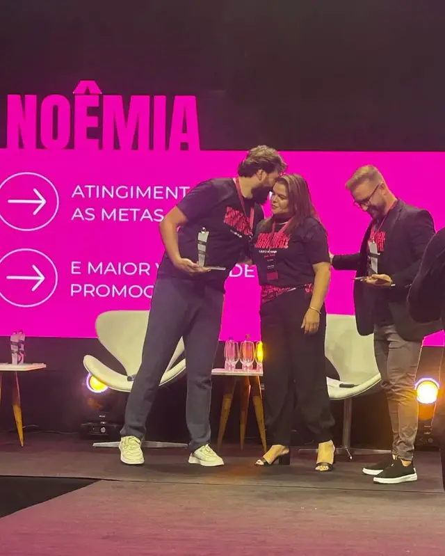 Noêmia recebendo o prêmio no palco da convenção do Grupo Abrange